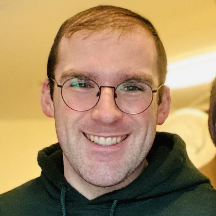 A profile picture of Alex Bair smiling and wearing glasses.